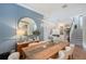 Open-concept dining room with wood table, blue accent wall, chandelier, and view to living room at 3921 Maravic Pl, Sarasota, FL 34231