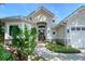 Inviting home exterior featuring a stone pathway to a wood door with tropical landscaping and a covered entry at 3921 Maravic Pl, Sarasota, FL 34231