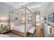 Serene main bedroom with a four-poster bed, tray ceiling, plantation shutters, and ensuite bathroom at 3921 Maravic Pl, Sarasota, FL 34231