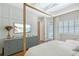 Lovely main bedroom with 4-poster bed, TV on dresser, white walls and plantation shutters at 3921 Maravic Pl, Sarasota, FL 34231