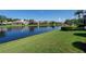 Picturesque backyard view featuring a tranquil lake and well-manicured lawn at 4257 Hearthstone Dr, Sarasota, FL 34238