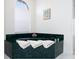 Bathroom featuring a corner soaking tub with marble surround and natural light at 4257 Hearthstone Dr, Sarasota, FL 34238