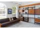 Bright living room featuring custom shelving, comfortable seating, and natural light from arched windows at 4257 Hearthstone Dr, Sarasota, FL 34238