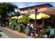 Casual outdoor dining area under yellow umbrellas with lush greenery and string lights at 4257 Hearthstone Dr, Sarasota, FL 34238