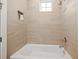 Bright bathroom featuring a bathtub with beige tile surround and brushed nickel fixtures at 4321 Marina View Way, Cortez, FL 34215