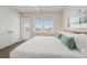 Light-filled bedroom featuring a white duvet, wood-look flooring, and a door to the outside at 4321 Marina View Way, Cortez, FL 34215
