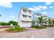 Charming three-story coastal home with white facade, dual balconies, and garage at 4321 Marina View Way, Cortez, FL 34215