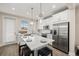 Bright, modern kitchen features white cabinets, stainless steel appliances, and an island with bar seating at 4321 Marina View Way, Cortez, FL 34215