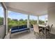 Relaxing covered patio with blue couch and dining table overlooking lush green trees at 4321 Marina View Way, Cortez, FL 34215