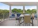 Covered patio with blue couch and dining table overlooking luscious green trees at 4321 Marina View Way, Cortez, FL 34215