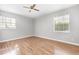 Neutral bedroom with laminate wood floors, two windows and ceiling fan at 4507 9Th W St # A2, Bradenton, FL 34207