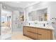 Elegant bathroom with double vanities, wood cabinets, and a well-lit mirror at 5450 Eagles Point Cir # 404, Sarasota, FL 34231