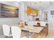 Bright dining area with a modern table, white chairs, and stylish pendant lighting above a breakfast bar at 5450 Eagles Point Cir # 404, Sarasota, FL 34231
