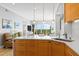 Stylish kitchen featuring a breakfast bar, modern lighting, and wood cabinets at 5450 Eagles Point Cir # 404, Sarasota, FL 34231