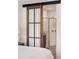 Bedroom view showing a glass barn door to a modern bathroom with white tiling at 5532 Summit Gln, Bradenton, FL 34203