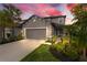 Charming two-story home with gray siding, landscaped yard, and a two-car garage under a beautiful colorful sunset at 5532 Summit Gln, Bradenton, FL 34203