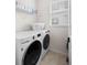 Bright laundry room with modern, front-loading washer and dryer set, and convenient shelving at 5532 Summit Gln, Bradenton, FL 34203