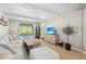 Bright and airy living room featuring a plush white sofa, stylish decor, and sliding doors to an outdoor pool at 5532 Summit Gln, Bradenton, FL 34203
