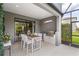Elegant outdoor kitchen with built-in grill and adjacent dining area, with seamless access to the home's interior at 5532 Summit Gln, Bradenton, FL 34203