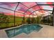 Screened pool with waterfall feature surrounded by lush greenery, offering a private outdoor oasis at 5532 Summit Gln, Bradenton, FL 34203