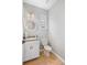 Charming powder room with patterned wallpaper, hardwood floors, and a classic vanity at 5532 Summit Gln, Bradenton, FL 34203