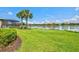 Beautiful backyard with a serene lake view, mature palm trees, and lush landscaping for outdoor living at 5740 Eagle Creek Rd, Sarasota, FL 34238