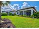 Lush backyard featuring a well-manicured lawn, screened lanai, and tropical landscaping for outdoor enjoyment at 5740 Eagle Creek Rd, Sarasota, FL 34238