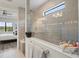 Walk-in shower with frameless glass panel and view into bedroom at 5740 Eagle Creek Rd, Sarasota, FL 34238