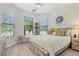 Bright bedroom showcasing windows with wooden-style flooring and a ceiling fan at 5740 Eagle Creek Rd, Sarasota, FL 34238
