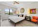 Stylish bedroom with decorative mirror, art, and a window view of the water at 5740 Eagle Creek Rd, Sarasota, FL 34238