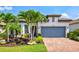 Charming single-Gathering home featuring lush landscaping, a brick driveway, and a two-car garage at 5740 Eagle Creek Rd, Sarasota, FL 34238