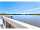 Scenic view of the lake from the wooden dock, surrounded by lush greenery and clear blue sky at 5740 Eagle Creek Rd, Sarasota, FL 34238
