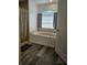 Bright bathroom featuring a soaking tub under a window and wood-look flooring at 5849 Wagon Wheel Dr, North Port, FL 34291