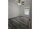 Neutral bedroom with gray wood-look floors, ceiling fan and large window at 5849 Wagon Wheel Dr, North Port, FL 34291