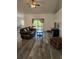 Spacious living room featuring wood-look floors, a leather sofa, and a ceiling fan at 5849 Wagon Wheel Dr, North Port, FL 34291