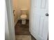 Small powder room with a toilet and neutral paint with wood-look flooring at 5849 Wagon Wheel Dr, North Port, FL 34291
