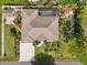 An aerial view of the house, featuring a screened-in pool, lush backyard, and fire pit at 5988 Viola Rd, Venice, FL 34293