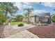 Spacious backyard featuring a fire pit, lush lawn, palm trees, and a screened-in patio, creating a perfect outdoor oasis at 5988 Viola Rd, Venice, FL 34293