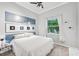 Cozy bedroom featuring a comfortable bed with a blue headboard and a well-lit window with stylish curtains at 5988 Viola Rd, Venice, FL 34293