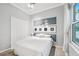 Bright bedroom featuring a comfortable bed with a decorative headboard and a well-lit window with stylish curtains at 5988 Viola Rd, Venice, FL 34293