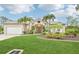 Charming home featuring a well-manicured lawn, palm trees, and a two-car garage at 5988 Viola Rd, Venice, FL 34293
