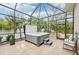 Enclosed patio featuring a hot tub, comfortable seating, and lush greenery, creating a perfect outdoor retreat at 5988 Viola Rd, Venice, FL 34293