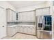 Spacious kitchen offers ample cabinet space, stainless steel refrigerator, and tile flooring at 5988 Viola Rd, Venice, FL 34293