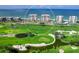 Aerial view of multiple condo buildings overlooking green golf course and beach at 601 Longboat Club Rd # 504S, Longboat Key, FL 34228