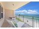 Balcony with outdoor seating overlooking sandy beach and blue ocean waters at 601 Longboat Club Rd # 504S, Longboat Key, FL 34228