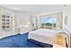 Airy bedroom with bright white decor, a desk with a view, and blue carpeting at 601 Longboat Club Rd # 504S, Longboat Key, FL 34228