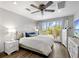 Light and airy bedroom with a large window, ceiling fan, dresser and luxury vinyl plank flooring at 601 Longboat Club Rd # 504S, Longboat Key, FL 34228
