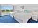 Shared bedroom with two beds, large windows, and blue carpeting at 601 Longboat Club Rd # 504S, Longboat Key, FL 34228