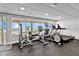 Well-equipped gym featuring machines, weights and a floor-to-ceiling window view of the outdoor pool and the ocean at 601 Longboat Club Rd # 504S, Longboat Key, FL 34228