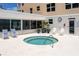 Relaxing outdoor hot tub on deck with chairs and partial view of the ocean at 601 Longboat Club Rd # 504S, Longboat Key, FL 34228